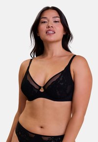 Soutien-gorge en dentelle noire avec des panneaux en maille et un petit accent doré au centre. Texture douce et forme triangulaire avec des bretelles réglables.