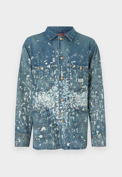 Τζιν μπουφάν με ανοιχτό μπλε ξέβγαλμα, διακοσμημένο με μοτίβα πιτσιλιών χρώματος, μυτερό γιακά, δύο μπροστινές τσέπες και χρυσά κουμπιά.