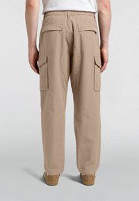 Beige cargo bukser med en afslappet pasform, flere sidelommer og et tekstureret stof. Elastisk talje for komfort.