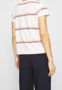 Kortærmet stribet T-shirt med vandrette linjer i pink, gul og marineblå på en hvid baggrund, rund halsudskæring og afslappet pasform.