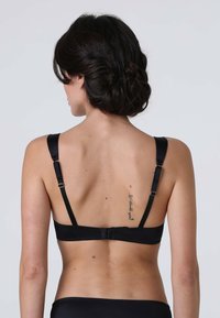Bra nero con spalline in satin regolabili, chiusura a gancio e occhiello e texture liscia; presenta un piccolo tatuaggio sulla schiena del portatore.