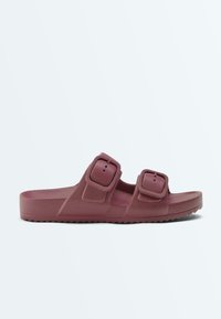 Sandale mule mauve unique avec deux larges brides réglables à boucle et semelle texturée, vue de profil sur fond blanc.