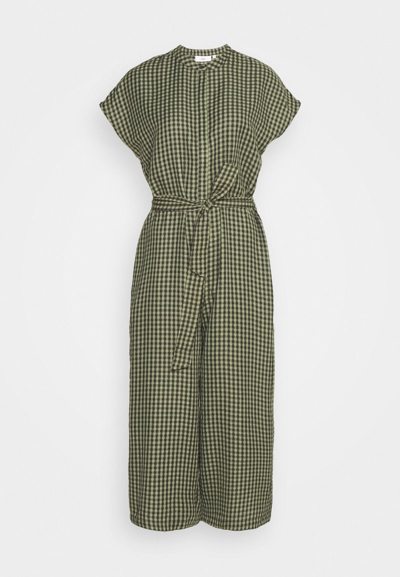 Combinaison à carreaux vert olive et noir avec manches courtes, encolure ronde, jambes larges et ceinture nouée à la taille.