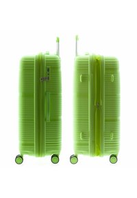 Maleta verde de carcasa dura con textura estriada, doble asa, candado de combinación incorporado y cuatro ruedas multidireccionales para facilitar la maniobrabilidad.