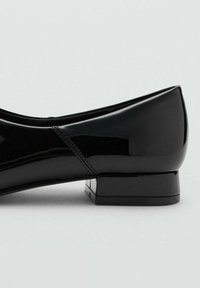 Černé lakované baletní byty s nízkým čtvercovým podpatkem, s hladkým povrchem a jemným prošíváním podél švů.