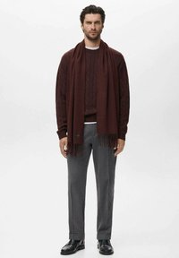 Bordeaux gebreide trui met kabelpatroon, bijpassende franjesjaal, grijze broek en zwarte schoenen; gladde texturen, moderne pasvorm.