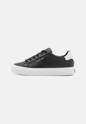 Black leather sneaker with a white rubber sole, round toe, and lace-up design. Features minimal branding on the side.