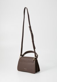 Sac à main en cuir marron avec une finition texturée, quincaillerie en ton doré, sangle longue réglable et une forme rectangulaire structurée.