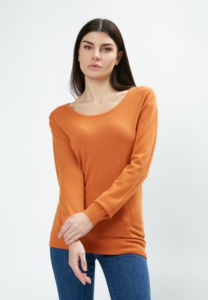 Langärmeliger Pullover in leuchtendem Orange, mit weitem Ausschnitt und geripptem Saum. Kombiniert mit engen blauen Jeans, die eine glatte Strickstruktur zeigen.