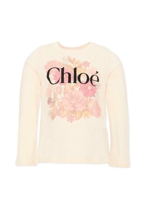 Chemise crème à manches longues avec un motif floral rose et beige et un grand texte noir ""Chloé"" sur la poitrine.