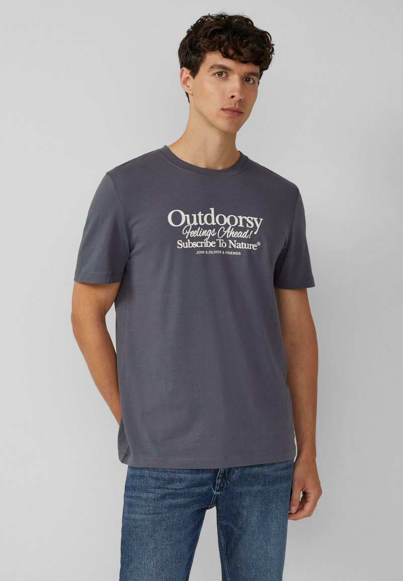 Grijze katoenen t-shirt met een ronde halslijn en korte mouwen, met daarop witte bedrukte tekst: "Avontuurlijke Gevoelens Vooruit! Abonneer Je Op De Natuur."