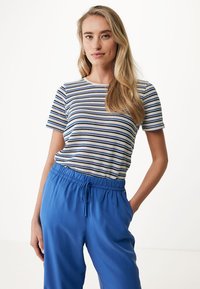 Pruhované tričko v bílé, námořnické modré a světlé modré barvě, spojené s volnými modrými kalhotami na šňůrku, vytvářejícími uvolněný a pohodlný vzhled.