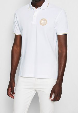 Koszulka polo z krótkim rękawem wykonana z białej bawełny z żółtym akcentem na kołnierzyku, z okrągłym złotym logo na piersi.
