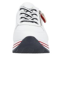 Weiße Sportschuhe mit schwarzen Schnürsenkeln, Reißverschlussdetails und roten sowie weißen Streifenakzenten; strukturierte Gummisohle; abgerundete Zehenform.