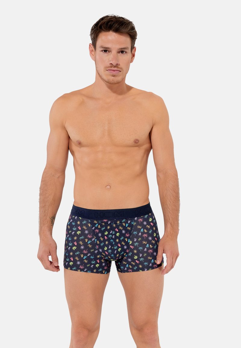 Boxer realizzati in tessuto elasticizzato con una base blu navy e impronte di mani multicolori. Vita elastica con marchio visibile nella parte superiore.