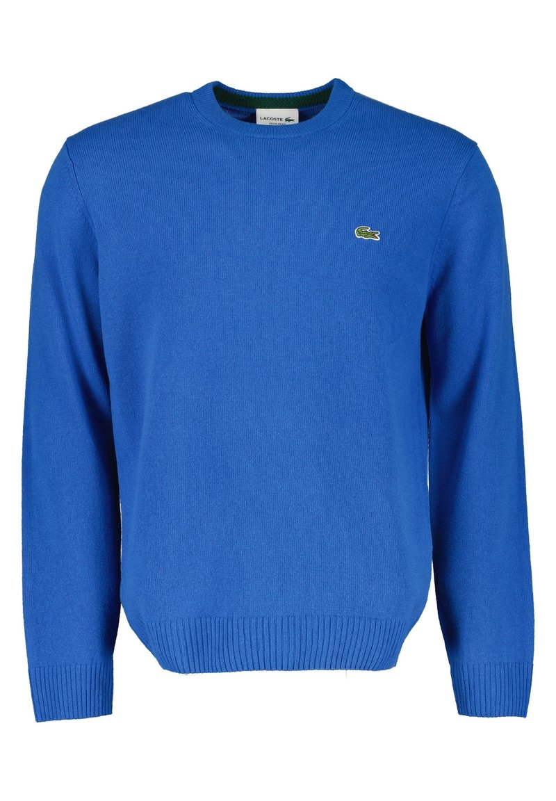 Blå stickad tröja av mjukt material med rund halsringning, ribbade ärmslut och nederkant, samt en grön Lacoste-logotyp på vänster bröst.