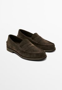 Para ciemnobrązowych zamszowych penny loafers z przeszywanym noskiem mokasynowym i niskim obcasem na białym tle.