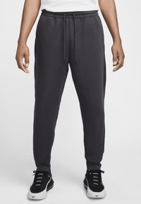 Mörkgrå sweatsbyxor i bomullsblandning, med elastisk midja och dragsnören, avsmalnande ben och sidofickor.