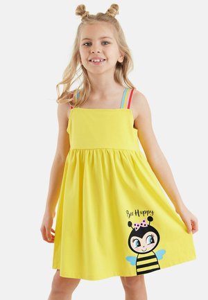 Gelbes ärmelloses Kleid mit einem gerafften Rock, das eine Biene-Grafik und den Text "Bee Happy" zeigt, akzentuiert durch bunt gestreifte Träger.
