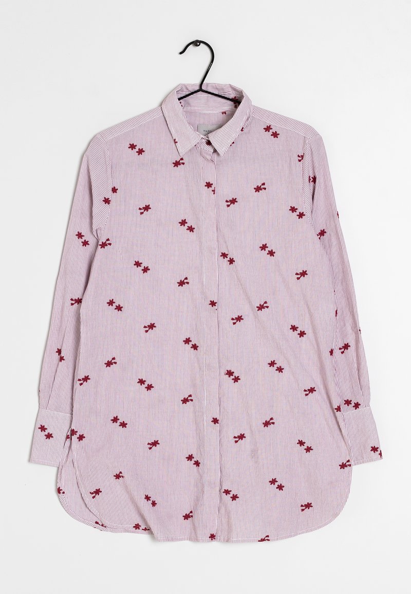 Chemise à manches longues boutonnée avec fines rayures verticales et petits motifs floraux rouges, suspendue sur un cintre noir sur fond blanc.