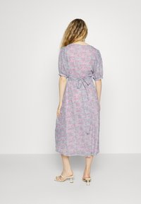 Vestido midi floral com mangas bufantes, apresentando um laço na cintura em cores pastel (rosa, azul, verde) e um tecido leve, ligeiramente texturizado.