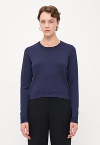 Marineblå langermet strikkegenser med rund hals og ribbestrikkede mansjetter, med avslappet passform og jevn tekstur.