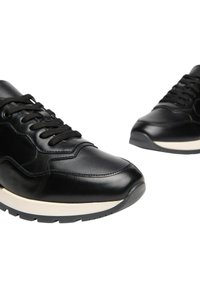 Sneaker in pelle nera con dettagli testurizzati, dotati di un intersuola bianca e suola in gomma nera. I lacci passano attraverso sei occhielli.