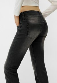 Jeans in denim nero con design aderente, vita a media altezza e leggero effetto sfumato sulle gambe. Dotati di tasche anteriori e posteriori.