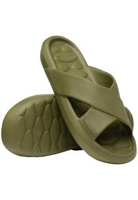 Olive green cross-strap slide sandals made of textured rubber, featuring a contoured footbed with circular pattern and logo detail.
