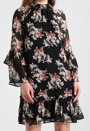 Robe noire à fleurs roses et rouges, manches longues transparentes avec poignets volantés et ourlet volanté fluide.