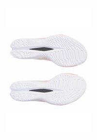 White athletic shoes with textured rubber soles, featuring a black groove in the middle and subtle orange accents on the upper side.