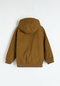 Brązowa kurtka z kapturem, z elastycznym paskiem w talii i mankietami, wykonana z teksturowanej tkaniny. Posiada duży kaptur i minimalne oznakowanie na plecach.