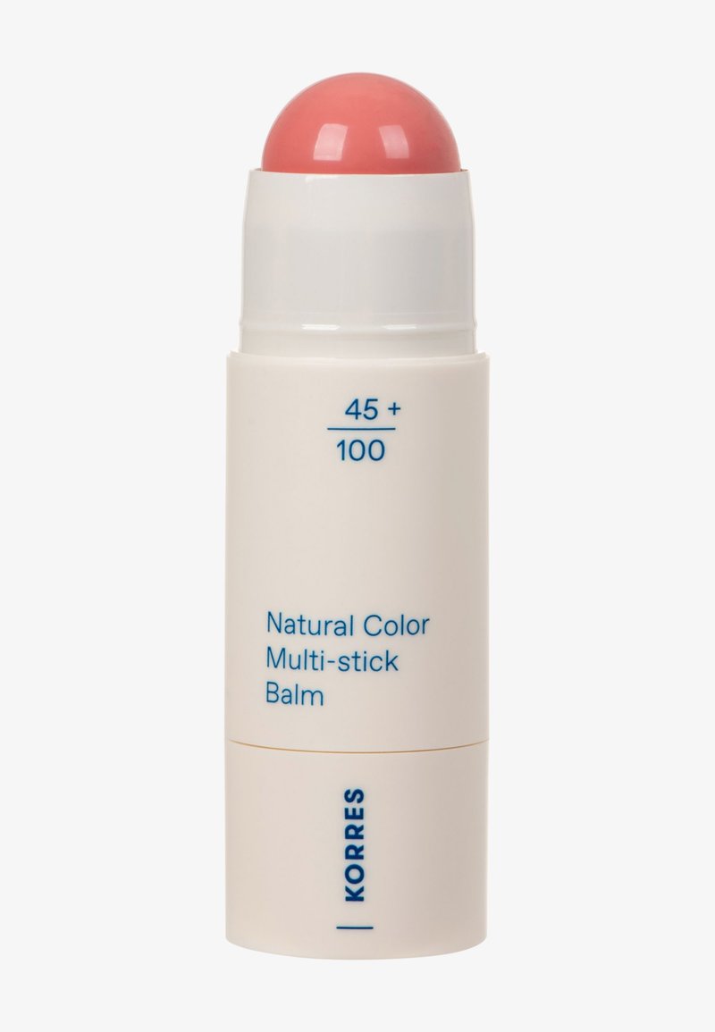 Balm multi-usage de couleur naturelle dans un tube cylindrique blanc avec un embout de baume rose arrondi et un texte bleu à l'avant.