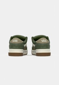 Zelené semišové a plátenné tenisky s bielymi akcentmi. Hrubá hnedá gumová podrážka, polstrovaný golier a logo "VANS" na päte.