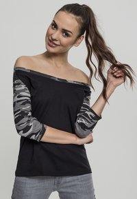 Top nero senza spalle con maniche a tre quarti in camuffamento grigio, realizzato in tessuto morbido. Presenta una vestibilità comoda e un design informale.