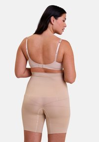 Beige shapewear met een lengte tot halverwege de dij, rekbaar materiaal, een gladde textuur en verstelbare bandjes. Naadloos ontwerp met gerichte compressiezones.