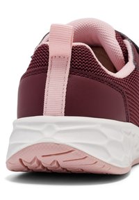 Nahaufnahme eines kastanienbraunen Sportschuhs mit einem pinkfarbenen Obermaterial aus Netzgewebe, einer pinken Fersenschlaufe und einer strukturierten weißen Sohle. Fokus auf die Designdetails.