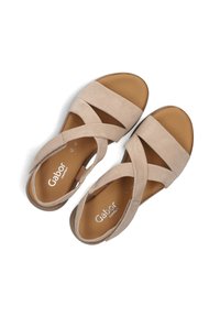 Beige suède sandalen met kruislings bandjes, ronde neus en afgeronde hak. "Gabor" merk op de binnenzool, gladde textuur.