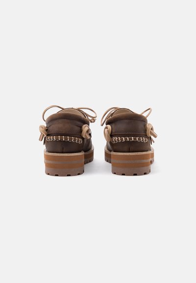 Paire de chaussures décontractées en cuir marron vues de dos avec des semelles épaisses rayées et des détails de lacets beige sur fond blanc.