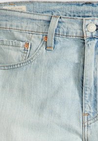 Light blue denim jeans featuring a classic five-pocket design, copper hardware, and contrasting stitching details, with a faint washed texture.