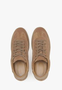 Brown suede sneakers with textured accents, rounded toe, and contrasting laces. Features a smooth leather interior and subtle side stitching.