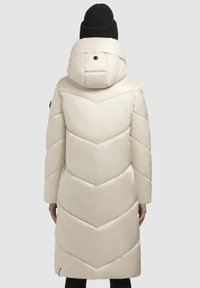 Cremfarvet pufferjakke med hætte, der har chevron-quilting, en glat finish og en lynlåslomme i bunden.