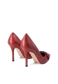 Tacchi alti in pelle rossa con punta affilata, finitura liscia e dettagli sottili nella parte anteriore. Presentano tacco a stiletto sottile e una soletta color nudo.