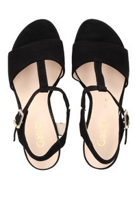 Černé semišové sandály s širokým pásem přes prsty a řemínkem na kotníku s stříbrnou sponou; béžová stélka s jemným brandingem.
