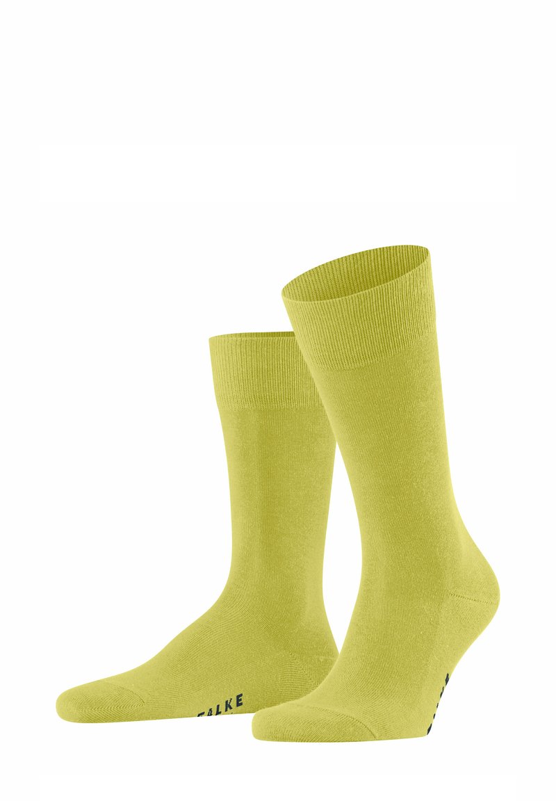 Limonengrüne Baumwollsocken mit glatter Textur, gerippten Bündchen und verstärktem Zehenbereich. Mit dem Markennamen „FALKE“ nahe der Basis.