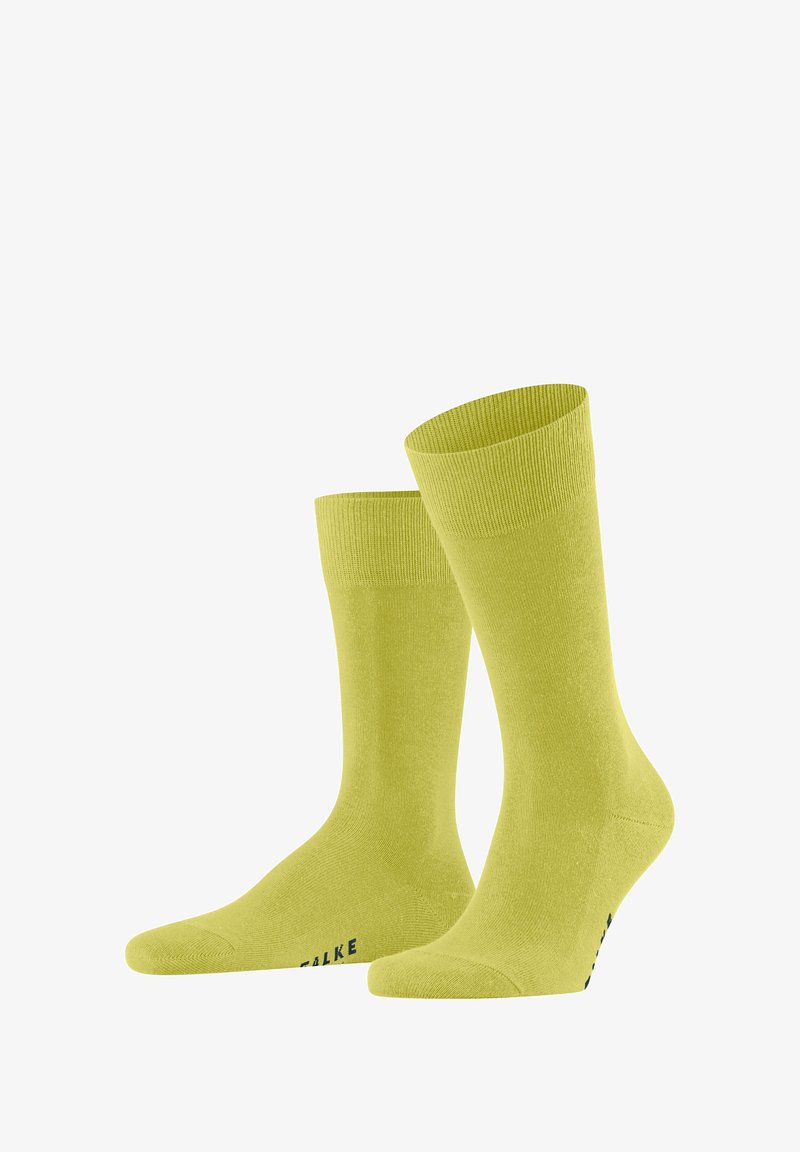 Limonengrüne Baumwollsocken mit glatter Textur, gerippten Bündchen und verstärktem Zehenbereich. Mit dem Markennamen „FALKE“ nahe der Basis.