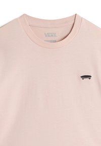 Ljusrosa bomullströja med rund halsringning och svart skateboardgrafik på vänster bröst. Mjuk textur, avslappnad design.