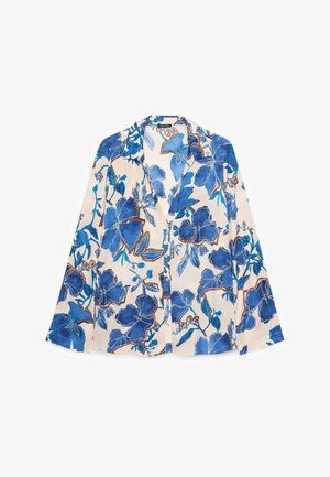 Langärmlige Bluse mit Knopfleiste, großem blauem Blumenmuster auf beigem Hintergrund, mit spitzem Kragen und lockerem Schnitt.