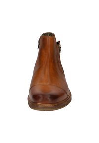 Bruine leren enkelboots met een gladde afwerking, ronde neus, zijrits en minimale stikdetails. Platte rubberen zool, veelzijdig ontwerp.