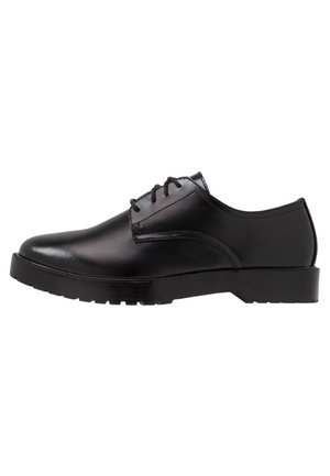 Sort læder Oxford snøresko med chunky sål og glat afrundet tå, vist i sideprofil.